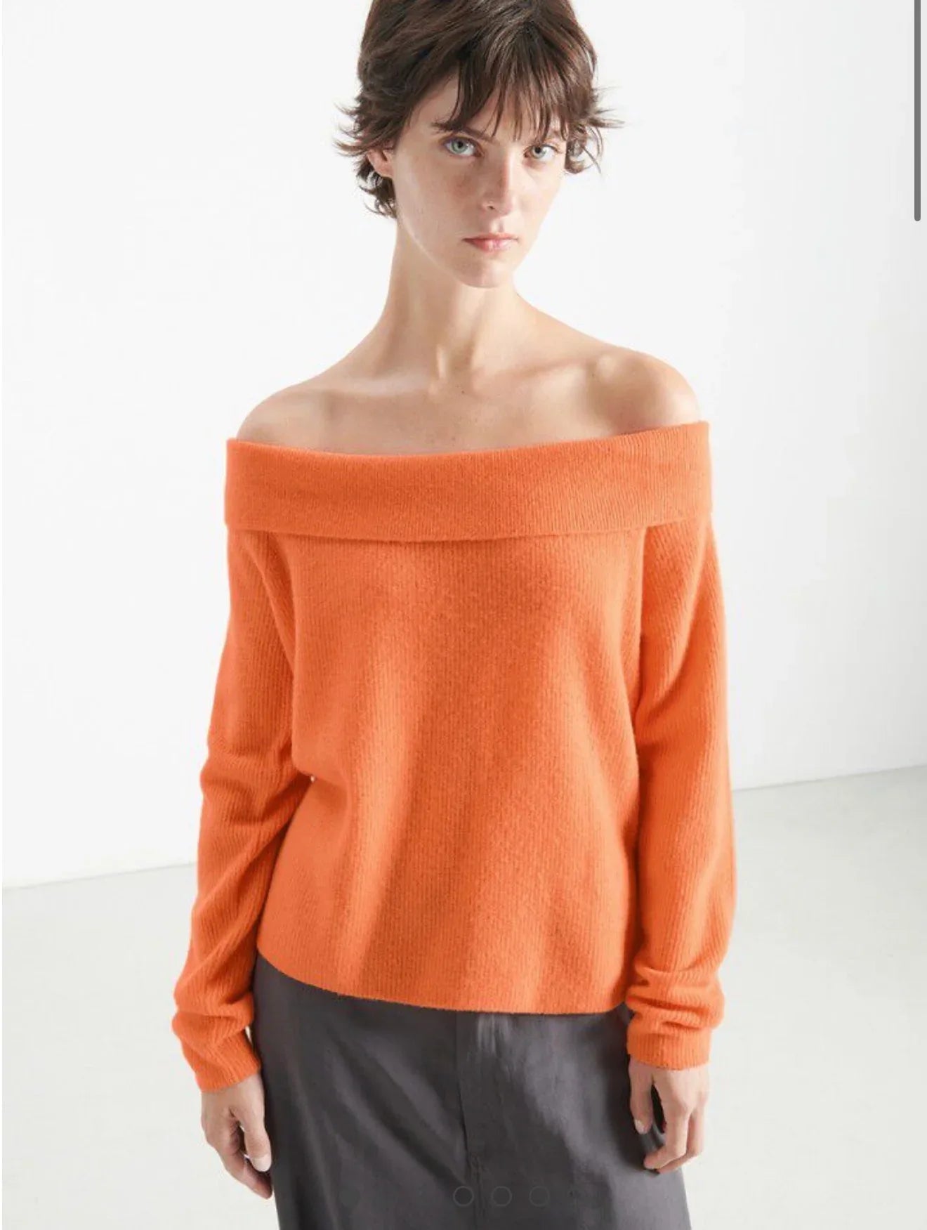 American Vintage Raxow 18J off-shoulder orange sweater with relaxed fit and ribbed cuffs, styled on a model.