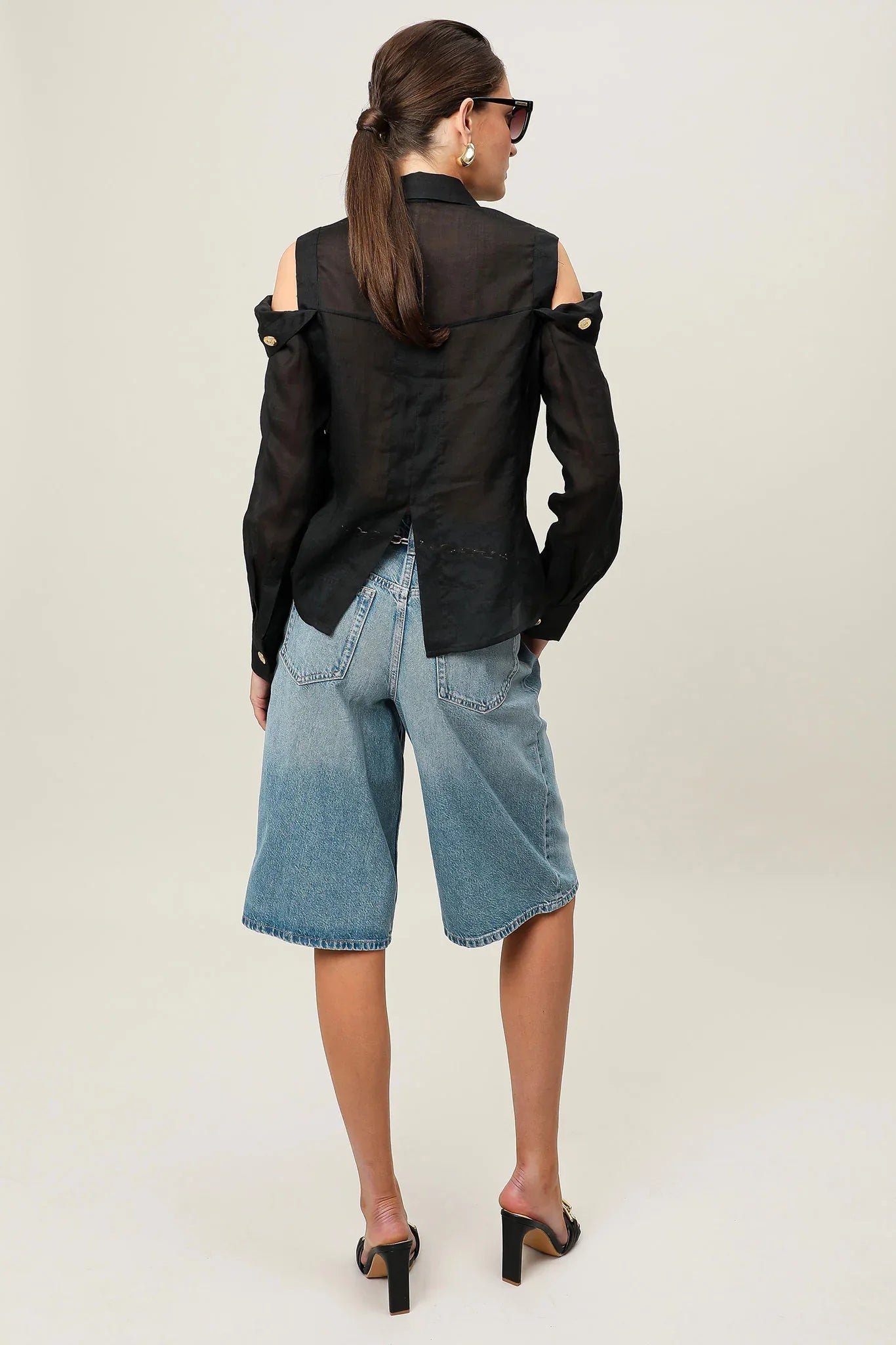 Black Realm Origin Vivre Shirt displayed on a hanger, showcasing its sleek design and fabric texture.