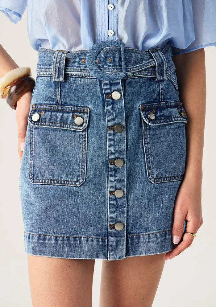 Aveline Denim Skirt by Mos the Label, featuring a classic cut and light blue wash, displayed on a neutral background.
