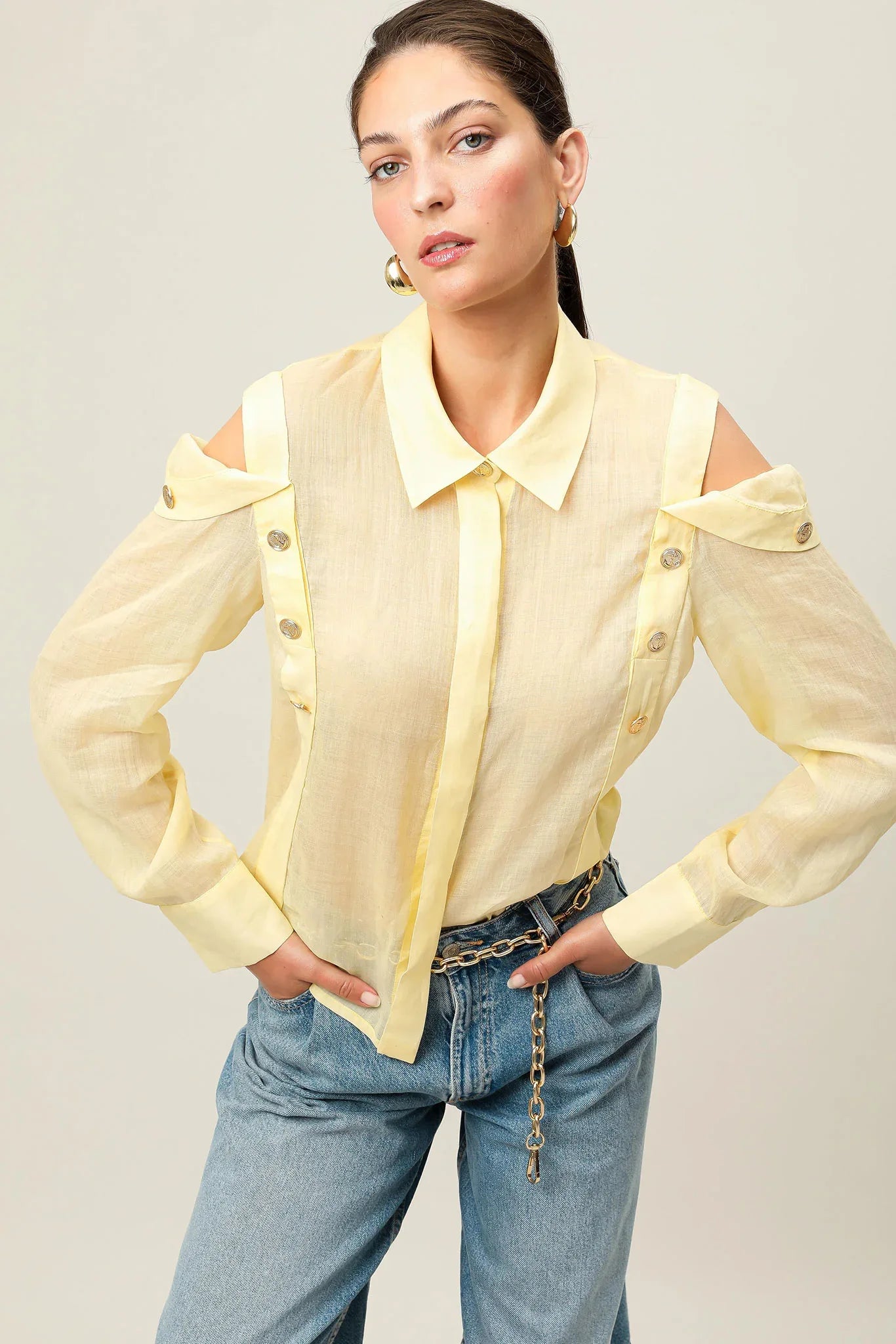 Yellow Realm Origin Vivre Shirt displayed on a hanger, showcasing its casual style and vibrant color.