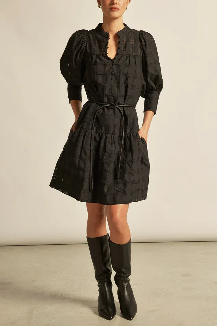 Black check Zoe Kratzmann Paloma Dress displayed on a hanger, showcasing its stylish pattern and elegant design.